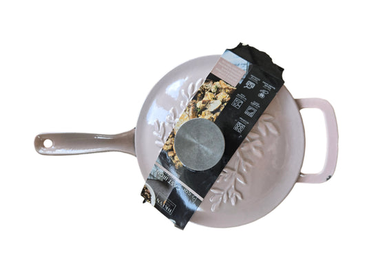 Light Pink saucepan with a black label on a white surface