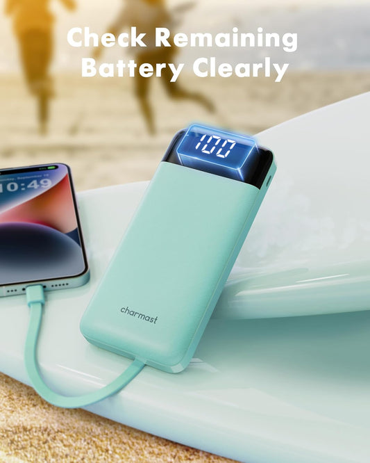 Turquoise power bank with digital display connected to a smartphone on a white surface.