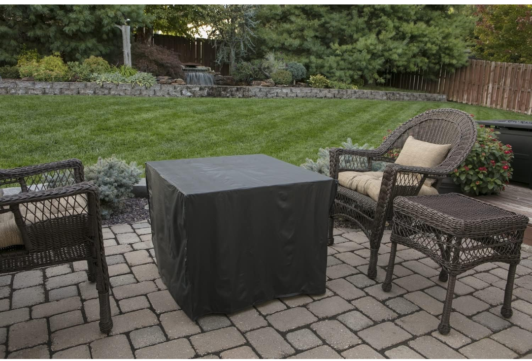 Outdoor patio set with chairs and a fire pit table on a stone patio.